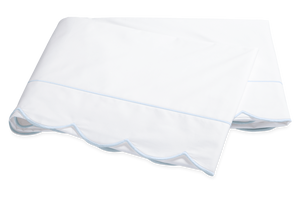 Two folded white bedsheets from the Matouk Butterfield Bedding Collection, Blue, feature elegant scallop detailing and blue-edged trim, crafted from luxurious Egyptian cotton percale.