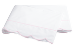 Two folded white pillowcases from the Matouk Butterfield Bedding Collection, featuring light pink piped edges and scallop detail, crafted from Egyptian cotton percale.
