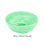 The image shows a small, round, light green bowl with a marbled wave pattern from the Mint Resin Serveware Collection by Nashi Home. Made from shatter-resistant resinware, it’s ideal for stylish home decor. Text reads "Wave Bowl Small.