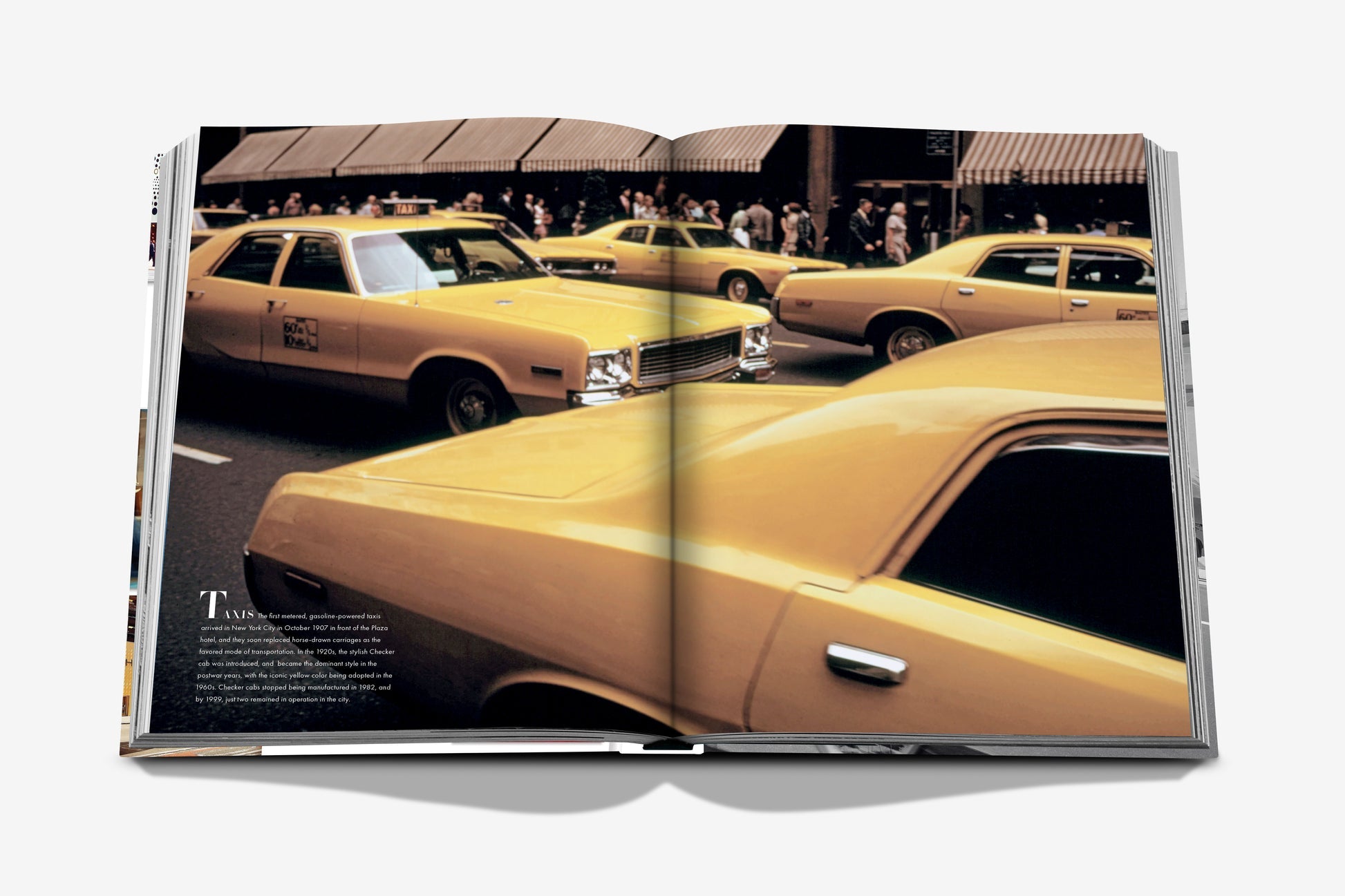 An open Assouline "5th Avenue" photo book displays yellow taxis on a vibrant city street, with bustling pedestrians and iconic buildings in the background.