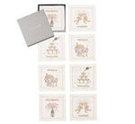 The Cheers Cocktail Napkin Set by Kim Seybert includes seven linen napkins with embroidered celebratory designs and text, arranged next to a gray box labeled "THE EMERSON." Ideal for festive gatherings.