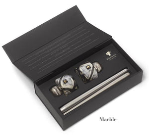 A black box includes a marble-patterned Baobab Collection Candle Holder Twins, featuring a hand-blown glass stopper top and a metal pour spout.