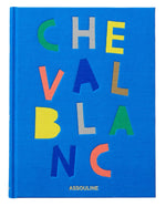 A blue book cover features colorful letters spelling "CHEVAL BLANC" vertically and horizontally, reflecting luxury hospitality, with the brand name "Assouline" at the bottom.
