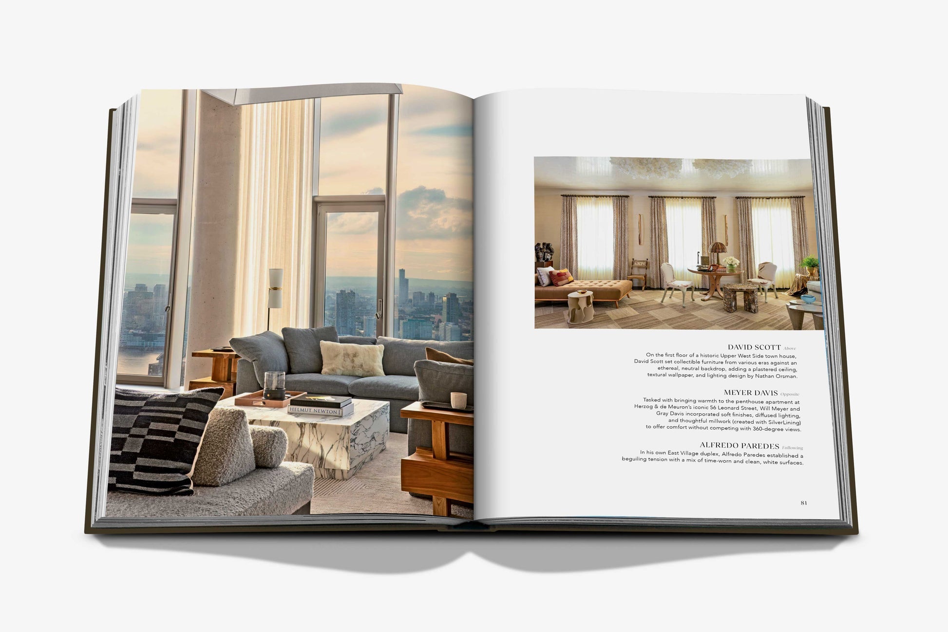 An open copy of "The Living Room" by Assouline shows modern, stylish living rooms with large windows and city views, accompanied by descriptive design text.