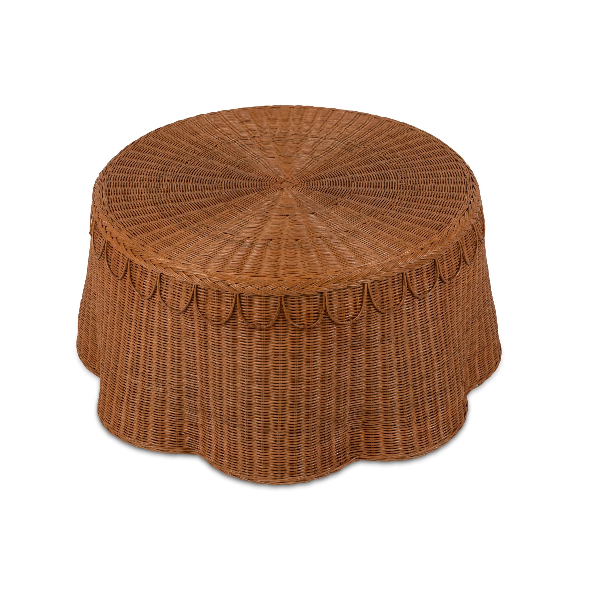 The Adeline Coffee Table by Sharland England features a round wicker design with a flat top and scalloped edges, shown against a white background.