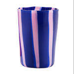 The Aquazzura Casa Murano Dolcevita Stripe Tumbler features vertical pink and light blue stripes on blue ceramic with a wavy rim, shown against a white background.