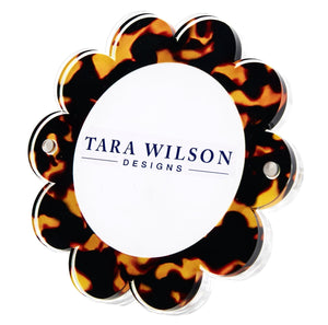 The Daisy Frame by Tara Wilson Designs is a flower-shaped acrylic frame with a tortoiseshell pattern—an ideal whimsical accent for your photo collection.