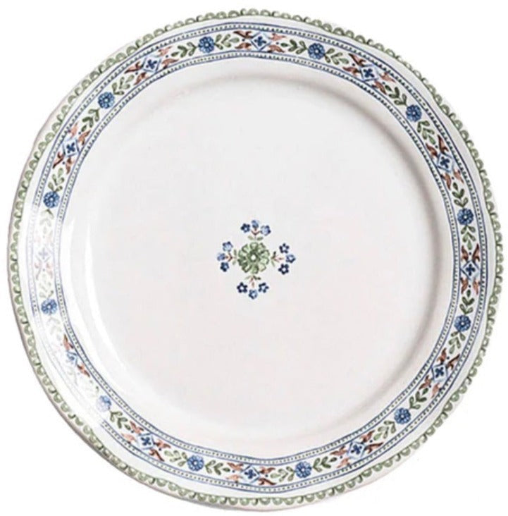 The Villa Seville Chambray Dessert Plate by Juliska features floral motifs around the rim and a central flower design—a charming addition to your dinnerware collection.