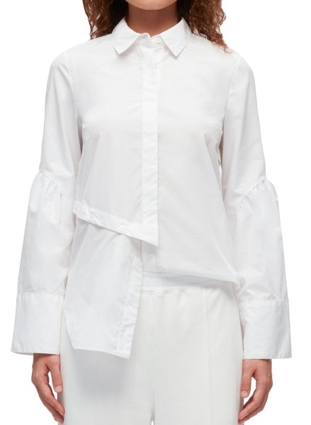 A woman wearing a white 3.1 Phillip Lim Long Sleeve Shirt with Asymmetric Button Panel exhibits modern tailoring.