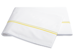 The Essex Lemon Bedding Collection by Matouk features folded white sheeting with two lemon-yellow stripes and satin stitch embroidery, elegantly displayed on a white background.