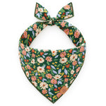 The Secret Garden Dog Bandana by Foggy Dog features a green base with a vibrant floral print of pink, orange, yellow, and white flowers accented by green leaves. It ties at the top for a stylish look.