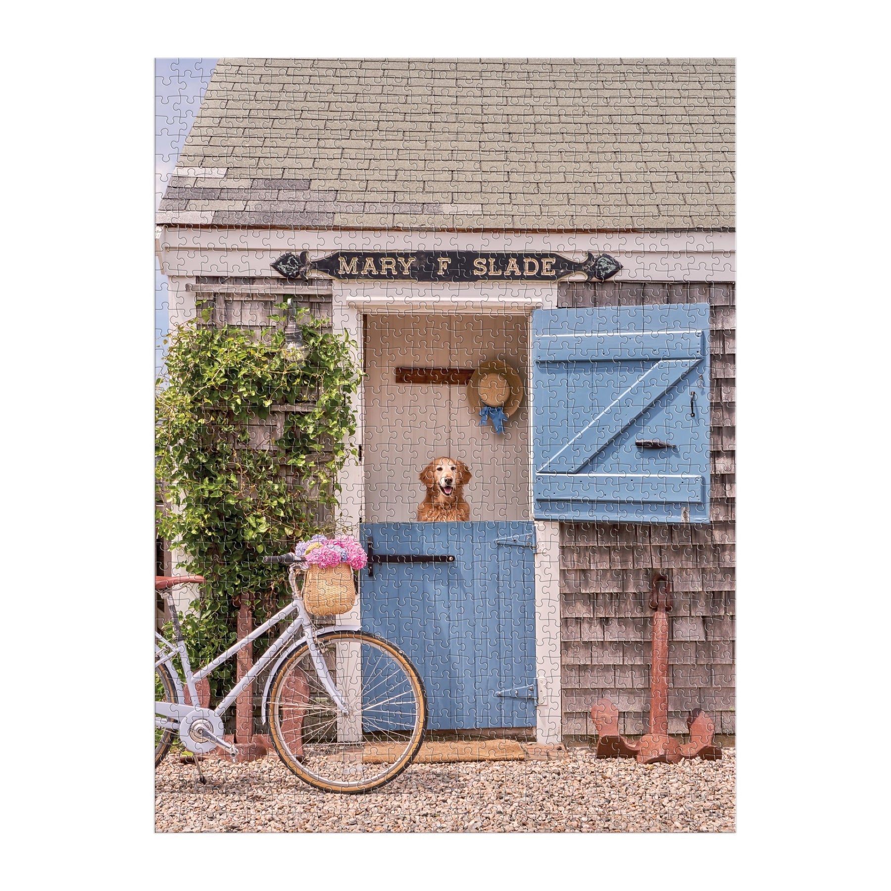 A dog gazes from a Dutch door on the Gray Malin 1000 Piece Puzzle Book Box, Nantucket by Chronicle Books. A bicycle with flowers and gardening tools complement the peaceful coastal setting.