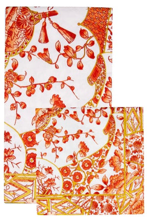 Two folded, eco-friendly triple-ply napkins from Caspari's Gilded Porcelain Coral Collection, featuring an orange and yellow floral and geometric print on a white background.