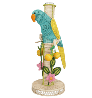 The El Pajaro Flower Vase by Mercedes Salazar features a colorful wicker parrot on a wrapped pole with yellow fruits, green leaves, and pink flowers atop a woven base, adding tropical style to your decor.