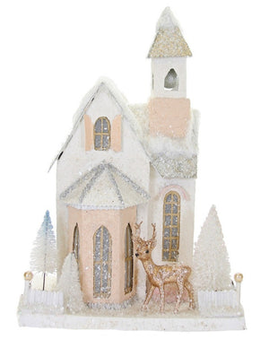 The Cody Foster Wintertide Country Church is a charming glittery miniature with a steeple, frosted trees, and a gold reindeer in front, all crafted from cardboard.
