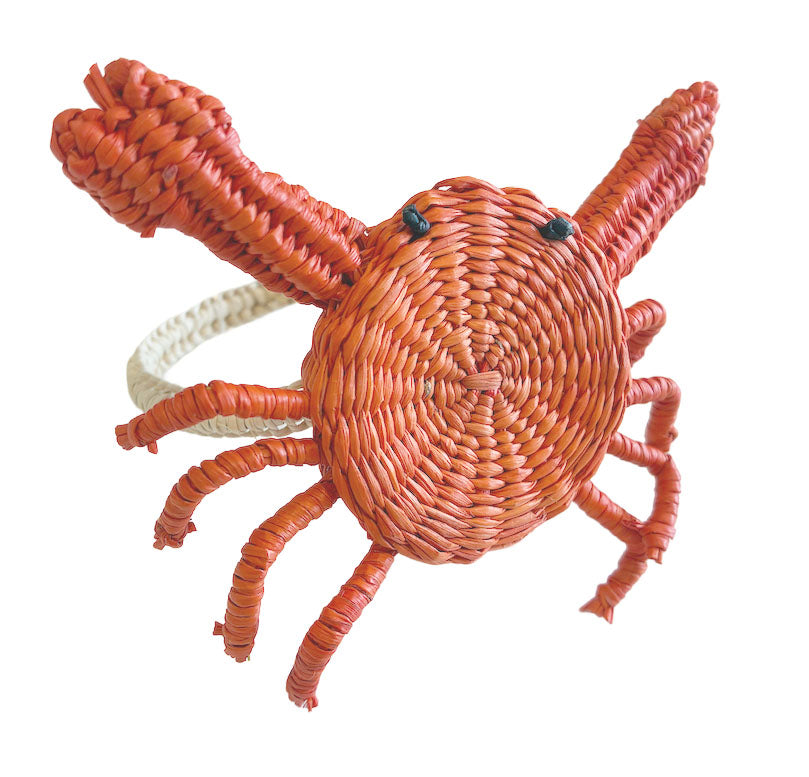 The Mercedes Salazar Crab Napkin Ring features a woven raffia design shaped like a red crab with raised claws and black bead eyes, adding coastal charm to your table setting.