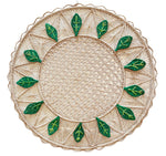 The Mil Hojas Placemat by Mercedes Salazar is a handwoven raffia mat in beige with an intricate geometric pattern and green embroidered leaves along the edge, adding a natural touch to your table setting.