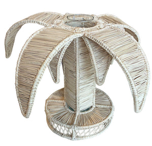 The Valley Flower Vase by Mercedes Salazar features a woven rattan design with a cylindrical base and palm-shaped fronds, adding tropical flair to your space.