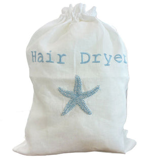 The Haute Home Hair Dryer Bag, Blue Starfish, is a white drawstring bag featuring "Hair Dryer" in blue letters and a blue starfish design—ideal for travel or storing your hair accessories.