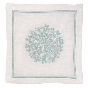 White linen napkin features a light blue embroidered coral design and matching stitched border. Pair it with Haute Home’s Sea Sponge Coaster Set for an elegant table setting.