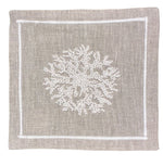 The Haute Home Sea Sponge Coaster Set features square beige linen coasters with white hand-embroidered coral designs and stitched borders—perfect for pairing with matching linen napkins.