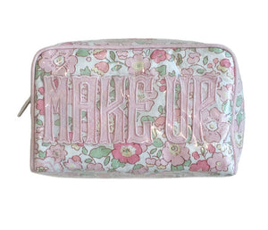 The Milan Cosmetic Case by Walker Valentine is a rectangular floral bag with "MAKE UP" in bold pink letters—ideal for organizing beauty essentials at home or while traveling.
