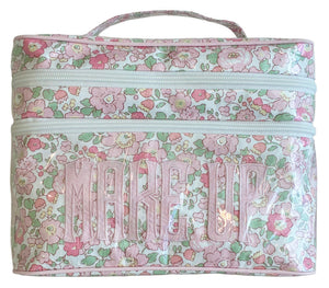 The Walton Travel Case by Walker Valentine features a floral pattern with pink and green flowers, double zippers, two spacious compartments, and "MAKE UP" in bold pink letters—ideal for stylish travel.