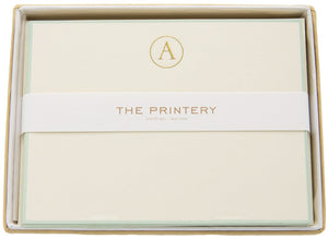 The Printery Initial Card Set includes cream note cards featuring a gold "A," hand-lined envelopes, and a branded band for an elegant presentation.