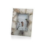 The Preto Agate Frame by Zodax is a rectangular, marble-patterned photo frame that showcases a picture of a person seated on stone steps against a white background.