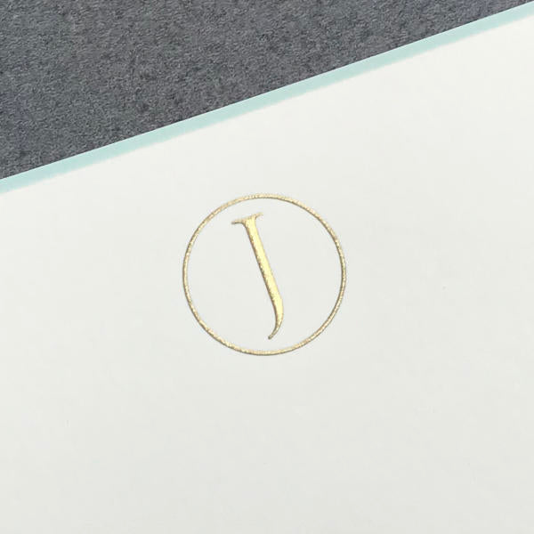 The Printery Initial Card Set features a gold letter "J" in a circle, centered on white with an aqua border and gray background—ideal for personalized gold initial note cards and hand-lined envelopes.
