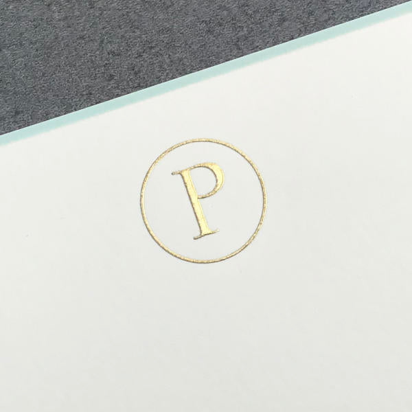 Printery’s Initial Card Set features a gold embossed “P” on white paper with a gray background and comes with hand-lined envelopes, offering an elegant and refined way to send your notes.