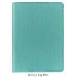 A 7" Leather Notebook by Graphic Image in robin’s egg blue, featuring a textured cover and closed design, is displayed on a white background. Below, the text reads “Robin’s Egg Blue.”.