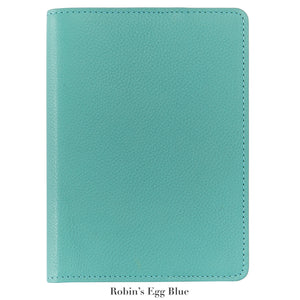 A 7" Leather Notebook by Graphic Image in robin’s egg blue, featuring a textured cover and closed design, is displayed on a white background. Below, the text reads “Robin’s Egg Blue.”.