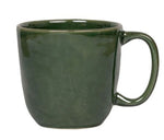 The Puro Basil Dinnerware Collection by Juliska features a verdant green ceramic coffee mug with a handle, adding artisanal charm to any stylish table setting.