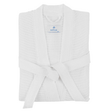 The Kiran Robe by Matouk is a folded, white, luxurious robe made from Turkish waffle fabric, featuring a front-tied belt and a visible "Matouk" label on the collar.