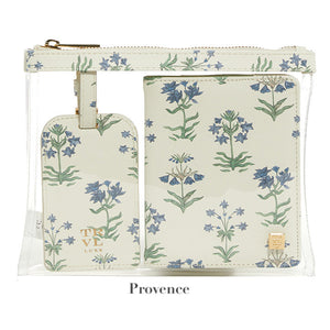 A clear pouch holds the TRVL Design LUXE Saffiano Travel Set: a cream passport cover and luggage tag with blue and green botanical designs. "Provence" appears below.