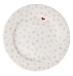 The Juliska Love You More Dessert/Salad Plate features a white ceramic design with pink hearts and a standout red heart near the rim, adding charming detail to your table setting.