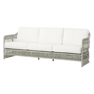 The Mara Outdoor Sofa in Rough 'N Tumble Blanca by PALECEK is a three-seater with a gray UV-protected wicker frame and plush white seat and back cushions.