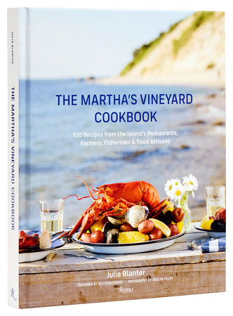 The cover of The Martha's Vineyard Cookbook by Rizzoli features a seafood feast with lobster, clams, and vegetables, all set on a beachside table to highlight New England culinary treasures.