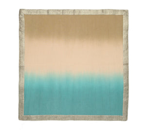 The Kim Seybert Dip Dye Napkin Set features rectangular napkins with a beige upper half, turquoise lower half in a subtle ombre reminiscent of hand-dipped dye, and is bordered by a light gray edge.
