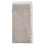 The Shell Edge Napkin Set by Kim Seybert features folded beige linen napkins with white lace trim, perfect for bohemian table settings and displayed against a white background.