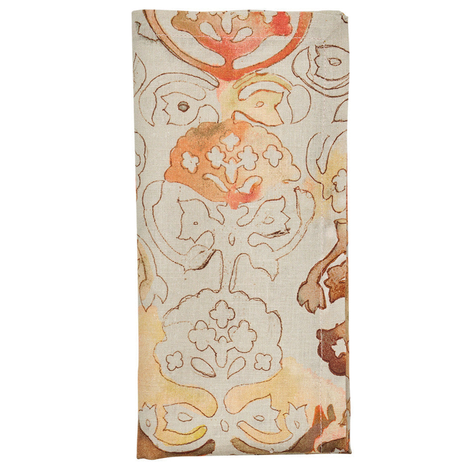 The Giverny Napkin Set by Kim Seybert features folded rectangular linen napkins with a beige background and Monet-inspired abstract floral patterns in orange, brown, and tan tones.