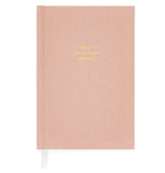 The Sugar Paper Gratitude Rose Journal is a pink hardcover with “Daily Gratitude Journal” in gold, a white ribbon bookmark, and space for daily check-ins and appreciation.