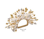 The Kim Seybert Fun Burst Napkin Ring features white, gold, and silver elements in a fan shape with metallic beads, silicone tubes, and a woven base. Text reads "White/Gold/Silver.