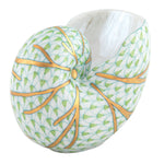 The Herend Small Nautilus Shell features a white base, green scale-like hand-painted pattern, and gold-accented ridges, highlighting the artistic craftsmanship of Herend porcelain.