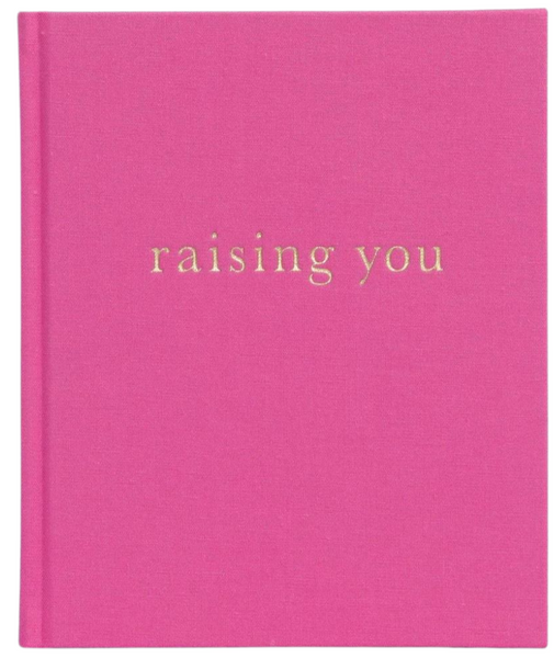 Pink Write To Me Raising You Letters to my Baby Rose book with the title "raising you" embossed in gold lowercase letters on the cover, serving as a special keepsake journal for parents.