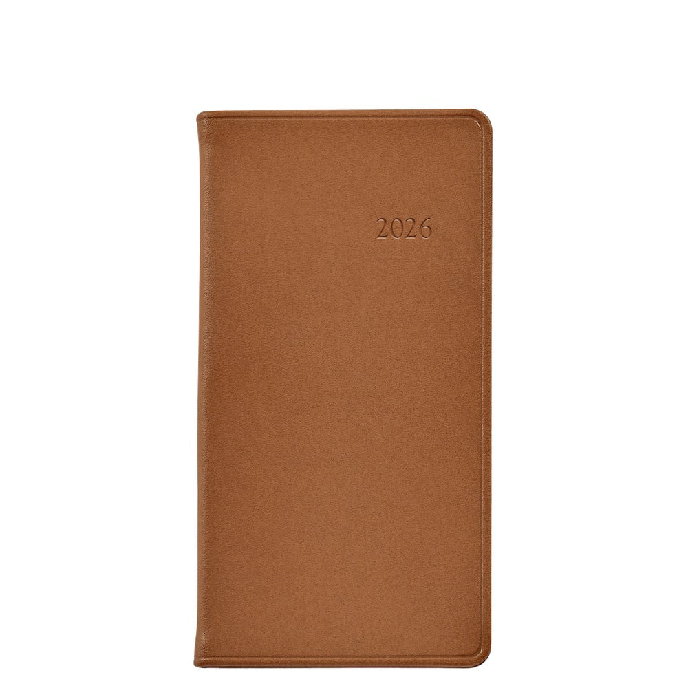 The 2026 Pocket Journal Planner Collection by Graphic Image features a brown leather-bound journal with "2026" embossed on the cover, shown closed against a white background.