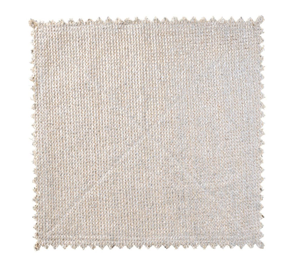The Kim Seybert Silver & Gold Stamped Reversible Placemat, featuring a luxurious woven texture and zigzag cut edges, is displayed on a white background.