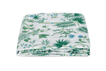 The Palmyra Bedding Collection in Emerald by Matouk features a neatly folded white bedsheet adorned with green palm fronds and a floral print on a plain background.