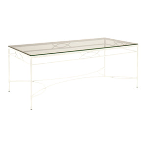 The Amalfi Cocktail Table in White Vermouth by Janus et Cie is a rectangular glass coffee table with a stainless steel frame, decorative curved accents, and handcrafted details.
